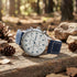 Timberland men's Stoughton silver dial blue leather watch in a bush setting.