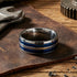 Titanium men's blue multi band ring on a work bench.