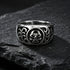 Men's tribal skull stainless steel ring on a black shale stone surface.