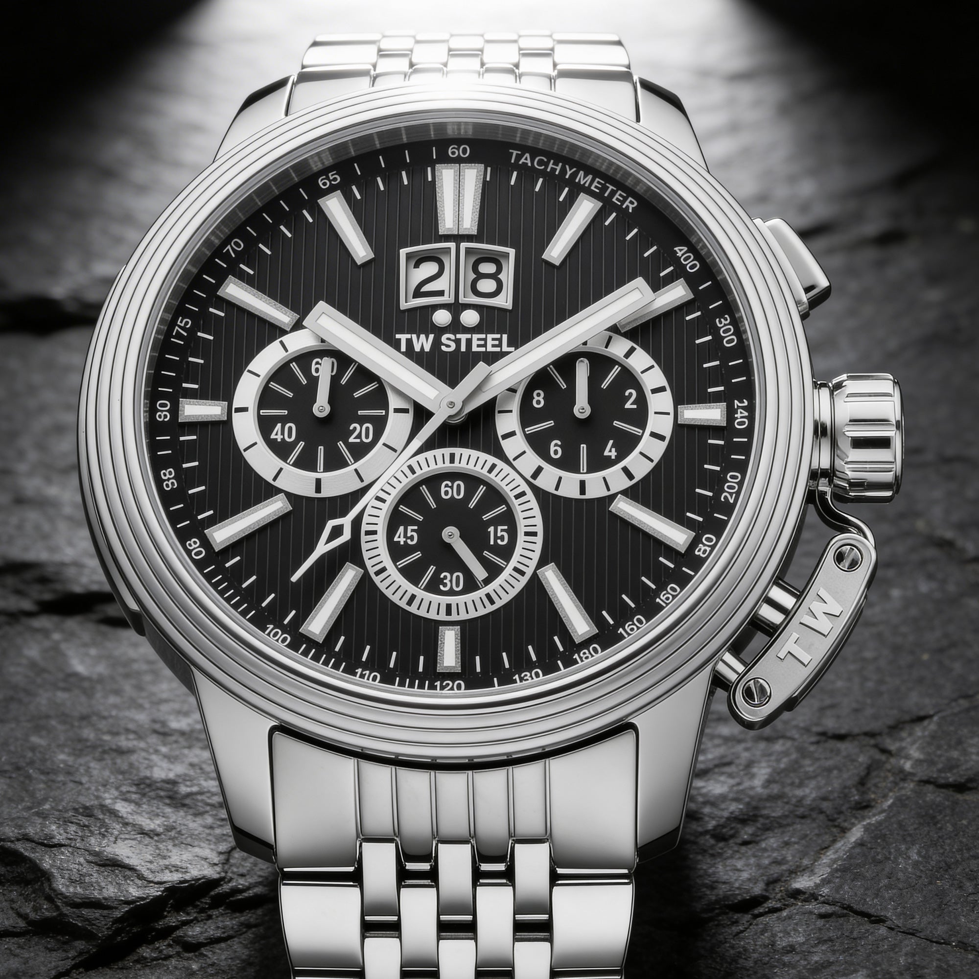 Close-up of TW Steel CEO Adesso CE7019 black dial chronograph watch on a black rock.