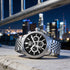 TW Steel CEO Adesso CE7019 black dial chronograph watch on a concrete ledge with a big city scape in the background.