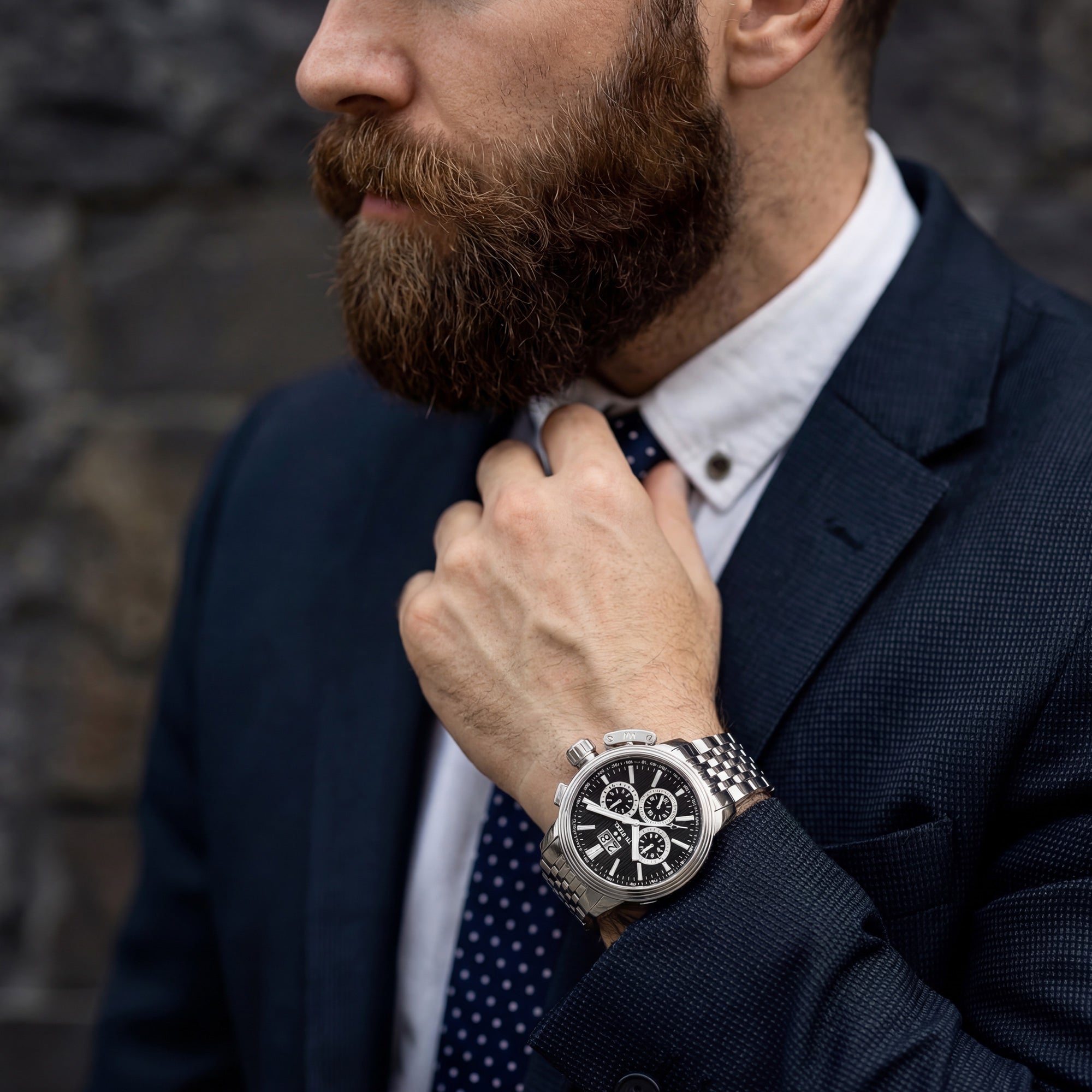 Bearded man adjusting his tie while wearing TW Steel CEO Adesso CE7019 black dial chronograph watch.
