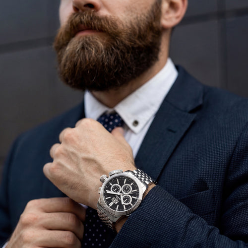 Man adjusting his tie while wearing TW Steel CEO Adesso CE7019 black dial chronograph watch.