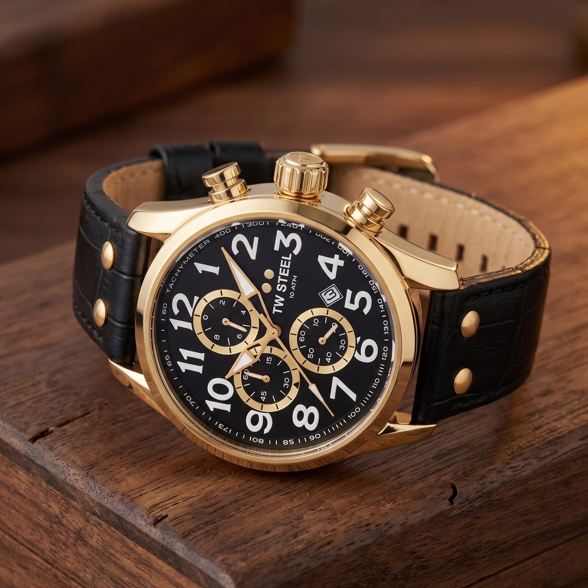 TW Steel VS88L Volante gold black dial numbers chronograph watch on an old wooden desk.