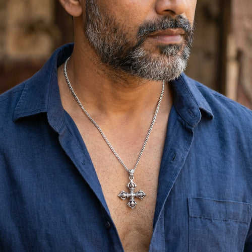 Bearded man in a blue open-neck shirt wearing a vajra cross sterling silver necklace.