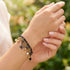 Close-up of a woman wearing an Engelsrufer wind rose gold and black boho pearl bracelet.