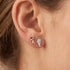 Woman wearing Engelsrufer angel wings silver rose gold mismatch stud earrings.