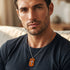 Man in a blue t-shirt wearing a cross wood inlay steel dog tag necklace.