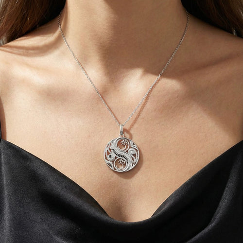 Close up of a woman wearing an Engelsrufer sterling silver yin yang om balance pendant.